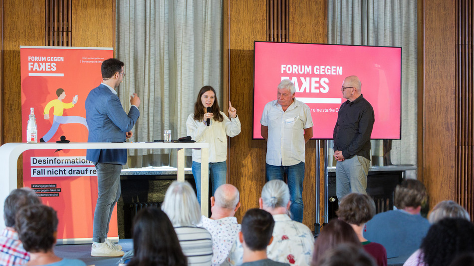 Jacob Birkenhäger interviewt Teilnehmer:innen auf dem Podium